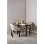 Moderner Esstisch aus dunklem Holz mit zwei beigen Stühlen und Dekoration in minimalistischem Design.