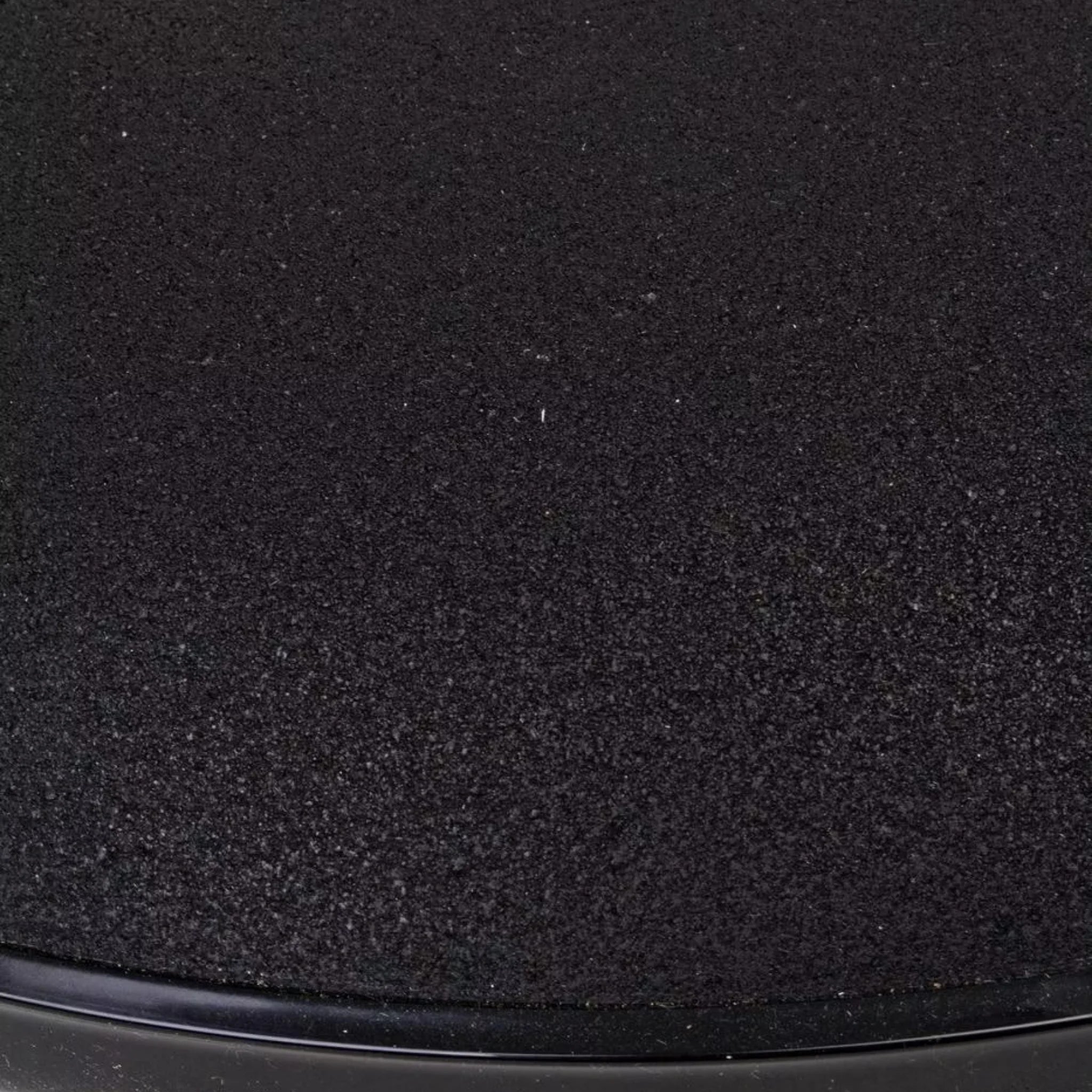 Nahaufnahme der schwarzen Granitoberfläche des runden Sonnenschirmständers Barry