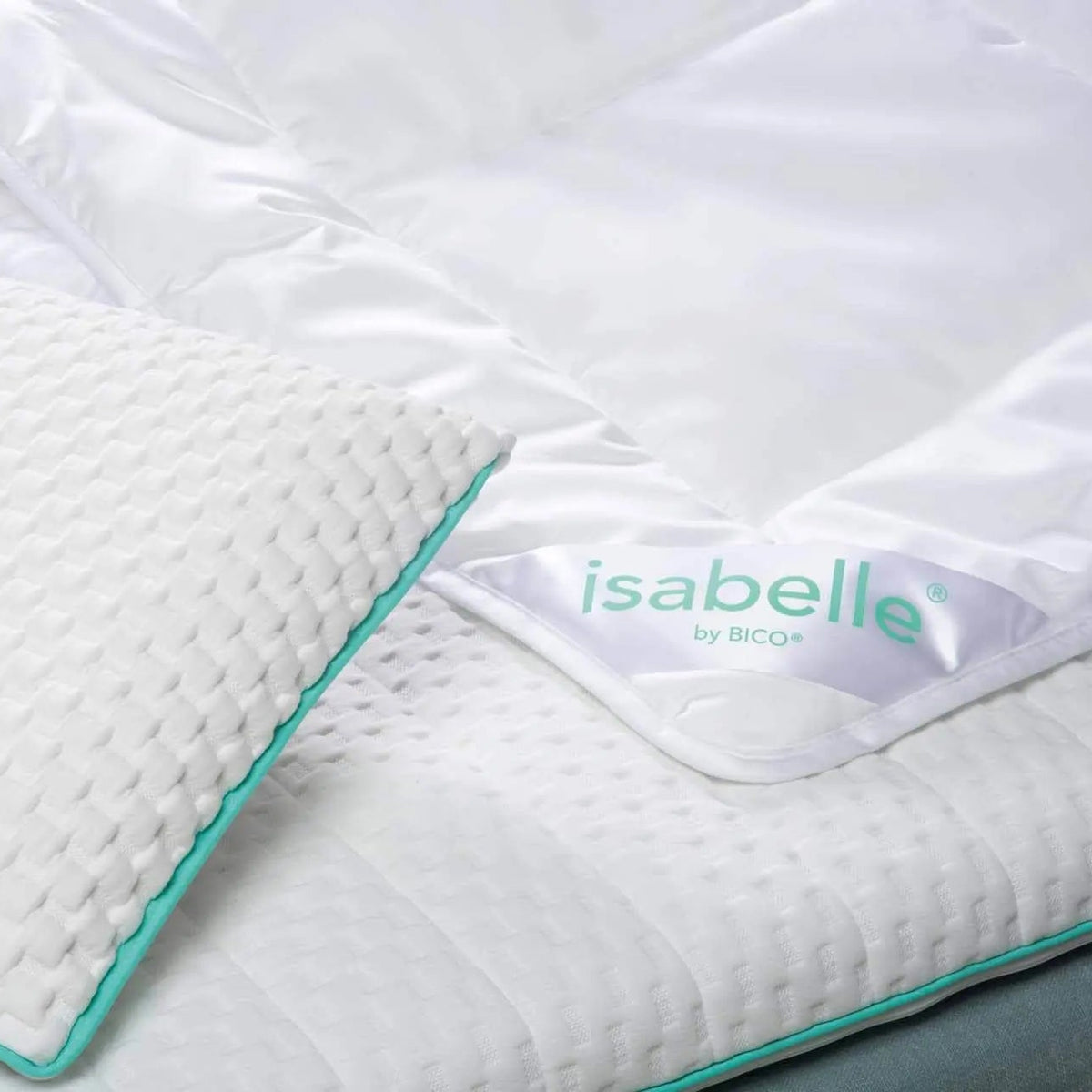 Isabelle by Bico Sommerdaunen mit türkisem Rand und Etikett auf weißem Bett