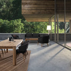 Moderne Terrasse mit Holzdach, Esstisch, schwarzen Stühlen und Lounge-Bereich im Grünen