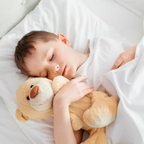 Schlafendes Kind mit Teddybär auf weißer Bico Kids Matratze 90x200 cm