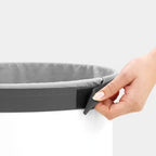 Hand befestigt Wäschesack mit Klettverschluss im Brabantia Wäschekorb 60L Weiss