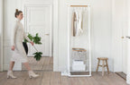 Brabantia Kleiderständer Linn Weiss mit Holzstange, Ablage und Wäschekorb in hellem Schweizer Wohnzimmer