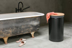 Brabantia Wäschekorb 60L Schwarz mit Korkdeckel im modernen Badezimmer neben freistehender Badewanne