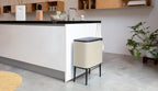 Brabantia Bo Touch Abfalltrenner 11L+23L in Soft Beige neben Kücheninsel auf schwarzen Metallbeinen