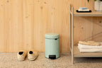Brabantia Tretheimer New Icon 3L in Jade Green neben Hausschuhen und Regal mit Handtüchern
