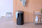 Brabantia Wäschekorb 60L Schwarz mit Holzdeckel im modernen Badezimmer mit Holzwand und Terrazoboden