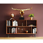 Goldene Athlet-Skulptur XL auf Holz-Bücherregal mit Deko-Accessoires vor weinroter Wand