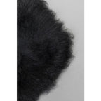 Schwarzes Lammfell Kissen Nahaufnahme – flauschiges, weiches Schaffell in Schwarz