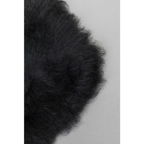 Schwarzes Lammfell Kissen Nahaufnahme – flauschiges, weiches Schaffell in Schwarz