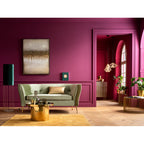Abstraktes Gemälde „Fields" über grünem Sofa in elegantem Wohnzimmer mit magentafarbenen Wänden und Goldakzenten