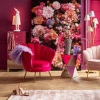 Stilvolles Wohnzimmer in Pink mit Samt-Sessel, Vase mit Blumen, Spiegel-Kommode und floralem Wandbild