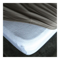 Weisser Molton-Matratzenschoner auf Boxspring-Matratze mit grauem Frottee-Spannbettlaken