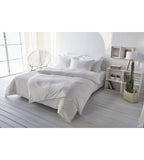 Weisses Satin-Kissenbezug-Set auf elegantem Doppelbett in hellem, modernem Schlafzimmer