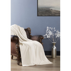 Cremefarbene Fleecedecke auf braunem Barock-Sessel vor blauer Wand mit Vase und Wandbild