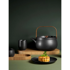 Ovales Holztablett Natur 35cm mit schwarzem Teeservice und Teekanne mit Holzgriff auf grünem Hintergrund