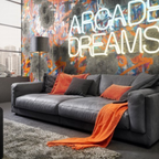Candy Megasofa King Size in Anthrazit mit orangefarbenen Kissen und Decke vor bunter Graffiti-Wand