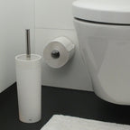 Kela WC-Garnitur Lis in Weiss mit Toilettenbürste und Papierhalter neben einem wandmontierten WC