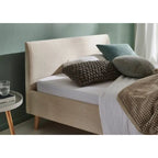 Bett Wicki in Cord Beige 140x200 cm mit Holzfüssen und dekorativen Kissen im modernen Schlafzimmer