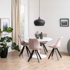 Runder weisser Marmor-Esstisch mit rosa Samt-Stühlen, schwarzer Pendelleuchte und Monstera-Pflanze im Esszimmer