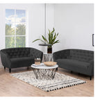 Moderne schwarze Sessel Ria von Actona mit geometrischem Couchtisch und eleganter Wohnzimmereinrichtung.