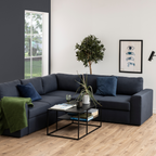 Actona Newton Salontisch Schwarz im modernen Wohnzimmer mit dunkelblauem Ecksofa und Zimmerpflanzen