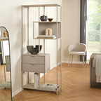 Actona Seaford hohes Regal in Greige mit Schubladen, dekoriert mit Büchern und Vasen, im modernen Wohnzimmer