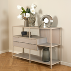 Actona Seaford Regal in Beige mit Schubladen, dekoriert mit Vasen, Blumen und Schalen auf Parkettboden