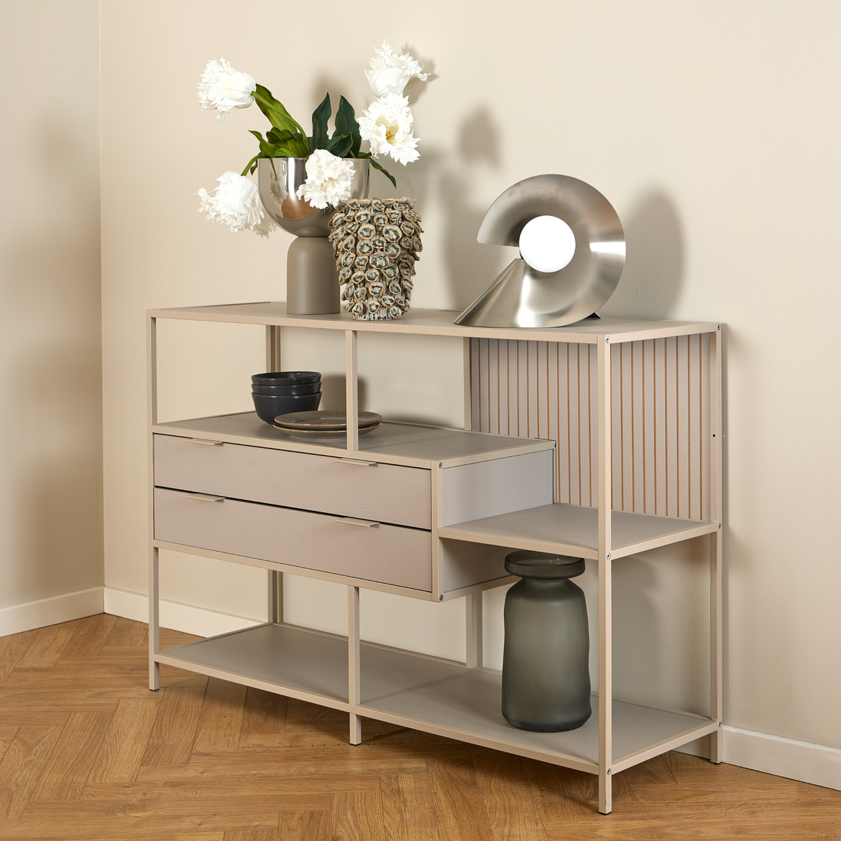 Actona Seaford Regal in Beige mit Schubladen, dekoriert mit Vasen, Blumen und Schalen auf Parkettboden