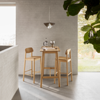 Actona Barlow Barstuhl aus hellem Holz an einem Bartisch, minimalistisches Wohndesign mit Industrielampe