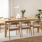 Actona Addi Armlehnenstuhl Beige an hellem Esstisch mit Kerzen und Blumen, skandinavisches Wohndesign