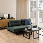 Actona Malling Bettsofa in Grün mit blauem Kissen im modernen Wohnzimmer mit Holzboden