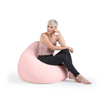 Frau sitzt entspannt auf rosa Magma Beanbag Sitzsack mit Rautenmuster und Samtbezug