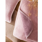 Magma Plaid Twin in Altrosa – weiche Fleece-Decke mit weissem Zierstich-Rand auf Holzregal