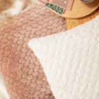Magma Kissen in Mink und Elfenbein 40x40 cm mit strukturiertem Bouclé-Stoff auf rosa Teppich