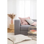 Graues Sofa mit rosa und grauen Cordsamt-Kissen, Beistelltisch mit Büchern und Pampasgras-Vase im Wohnzimmer