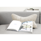 Beiges Cord-Lesekissen auf grauem Sofa mit aufgeschlagenem Buch – Magma Shara Nackenkissen