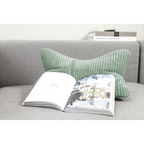 Grünes Cord-Lesekissen auf grauem Sofa mit aufgeschlagenem Buch – Magma Shara Nackenkissen