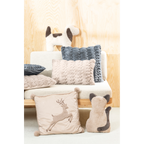 Gemütliche Plüschkissen in Beige und Blaugrau sowie Tierkissen auf hellem Sofa mit Holzwand