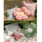 Blumenkissen Minnie in Pink und Grün auf Rattan-Gartenbank mit Rüschenkissen im Outdoor-Setting