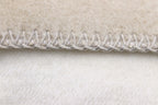 Biederlack Kuscheldecke Doubleface in Ecru mit sichtbarer Overlocknaht – weiche Wenddecke in Nahaufnahme