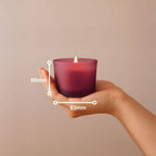 Bolsius True Joy Duftkerze im Glas, Vanille, Bordeauxrot, 83x66mm, in einer Hand gehalten, brennende Flamme