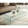 Moderner Glas-Salontisch mit Ablage im Wohnzimmer, dekoriert mit Vase und Büchern, vor beigem Ledersofa.