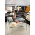Moderner Glas-Couchtisch mit Ablage im Wohnzimmer, dekoriert mit Büchern und Korb, vor grauem Ecksofa
