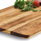 Zeller Schneidebrett aus Holz mit dekorativem Muster, frischen Kräutern und Tomaten