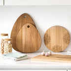 Zeller Schneidebrett-Set aus Holz mit Mandala-Gravur, verschiedene Formen, dekorativ auf Küchentheke arrangiert