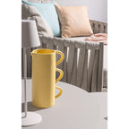 Bizzotto LED Tischlampe Etna Weiss auf rundem Tisch neben gelbem Krug und grauem Loungesofa mit Kissen