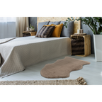 Lalee Kunstfell Teppich Cosy in Beige vor einem Doppelbett im modernen Schlafzimmer