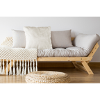 Gemütliches Naturholz-Sofa mit cremefarbenen Lalee Heaven Kissen, Makramee-Decke und Rattan-Hocker auf Holzboden