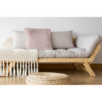 Lalee Heaven Kissen in Rosa auf einem Holzsofa mit beigen Kissen und Makramee-Decke im Boho-Stil